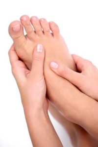 young woman massages her foot. on a white background.